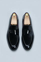 Black velvet loafers with elegant buckle, perfect for formal wear and special occasions.